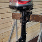 Mariner outboard motor on display against a wooden wall