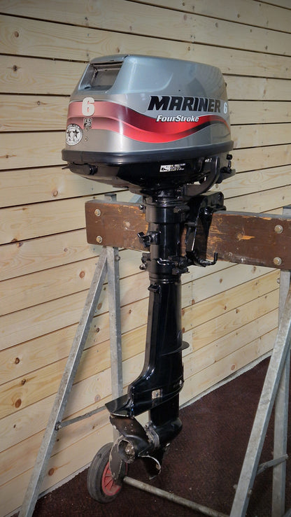 Mariner outboard motor on display against a wooden wall
