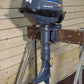 Yamaha outboard motor on a stand against a wooden wall