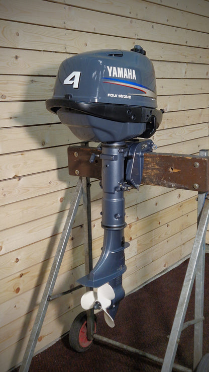 Yamaha outboard motor on a stand against a wooden wall