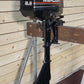 Black Mercury outboard motor on a stand against a wooden wall.