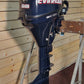 Evinrude outboard motor on a stand against a wooden wall