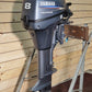 Yamaha outboard motor on a stand against a wooden wall