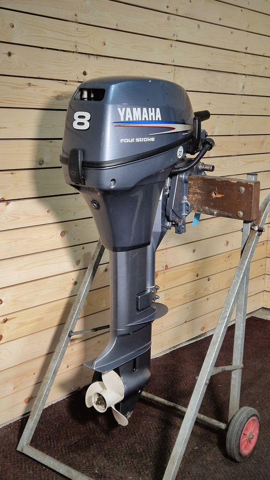 Yamaha outboard motor on a stand against a wooden wall